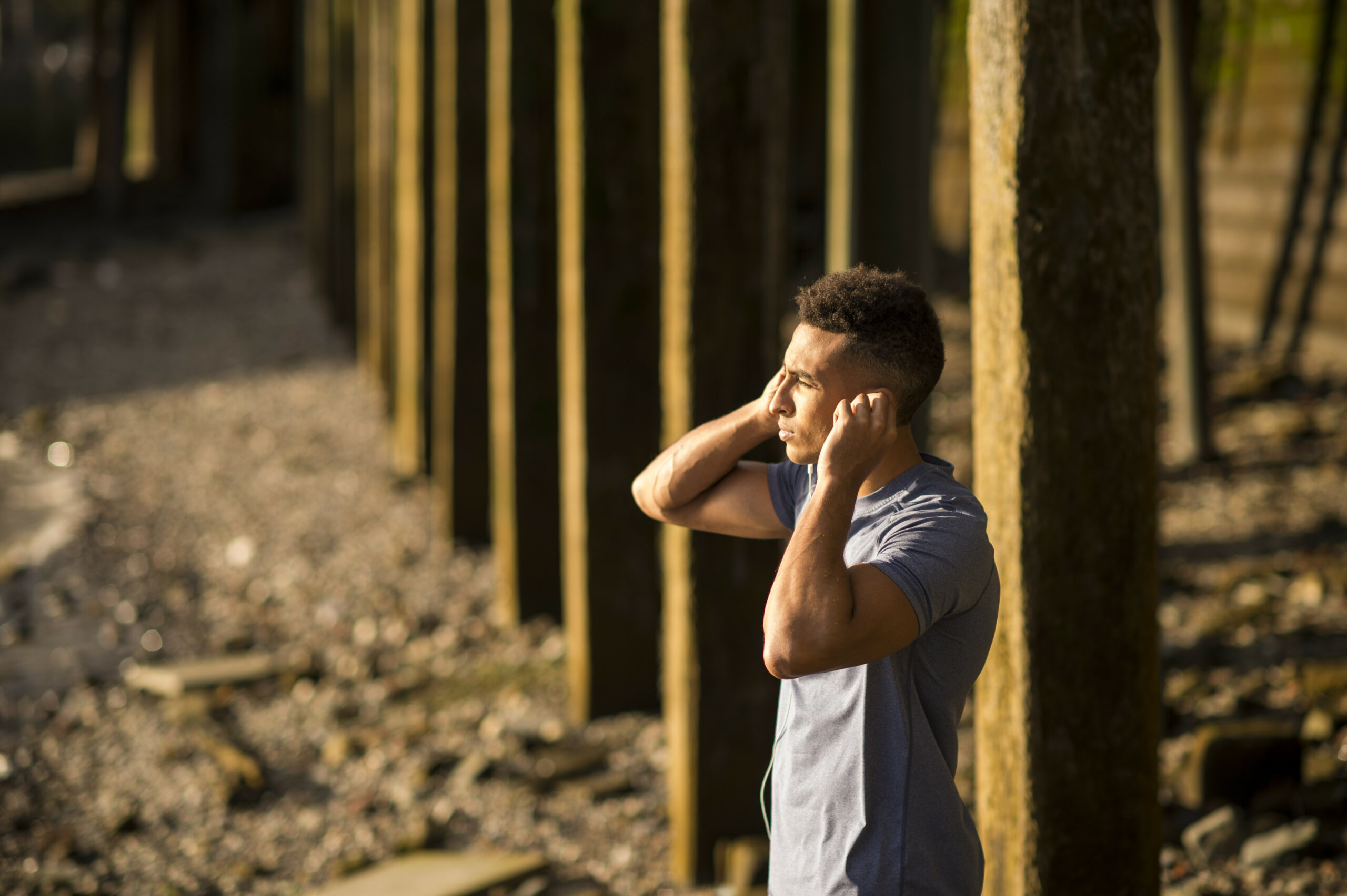 Man stretching under bridge, Wapping, London, UK